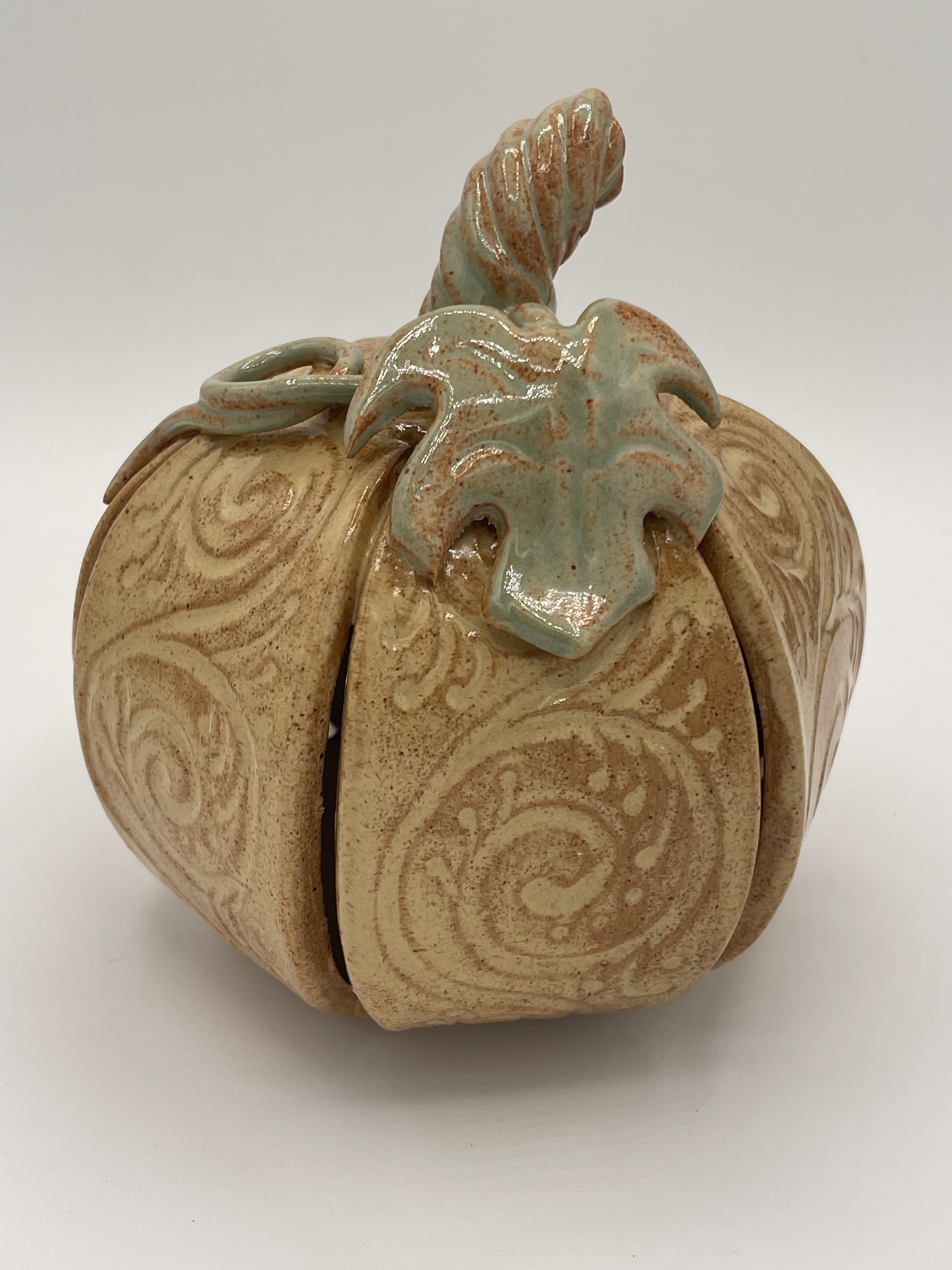 Yellow ceramic pumpkin with raised spiral filigree and sculpted stem