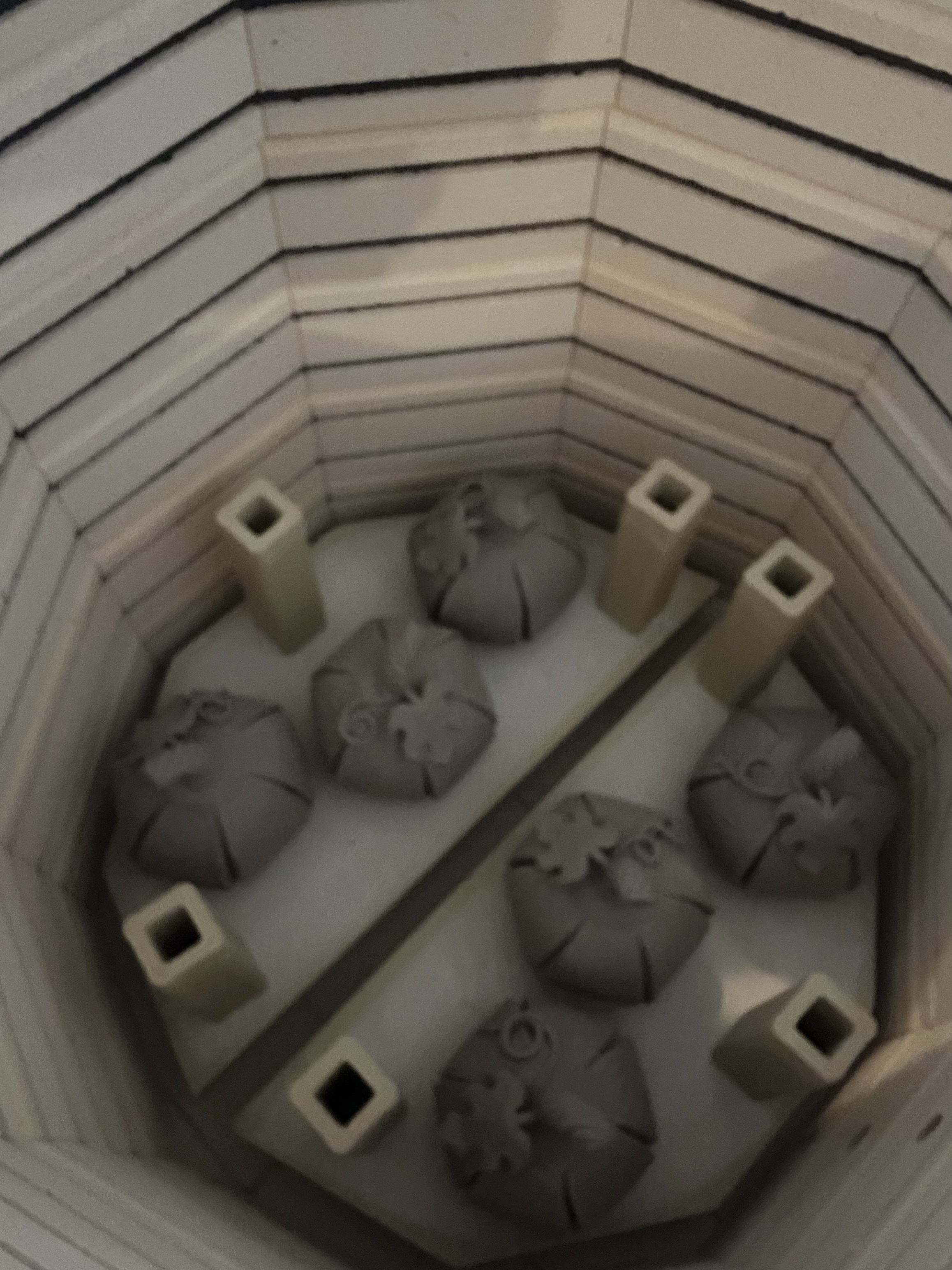 Ceramic pumpkin forms arranged inside a kiln for firing