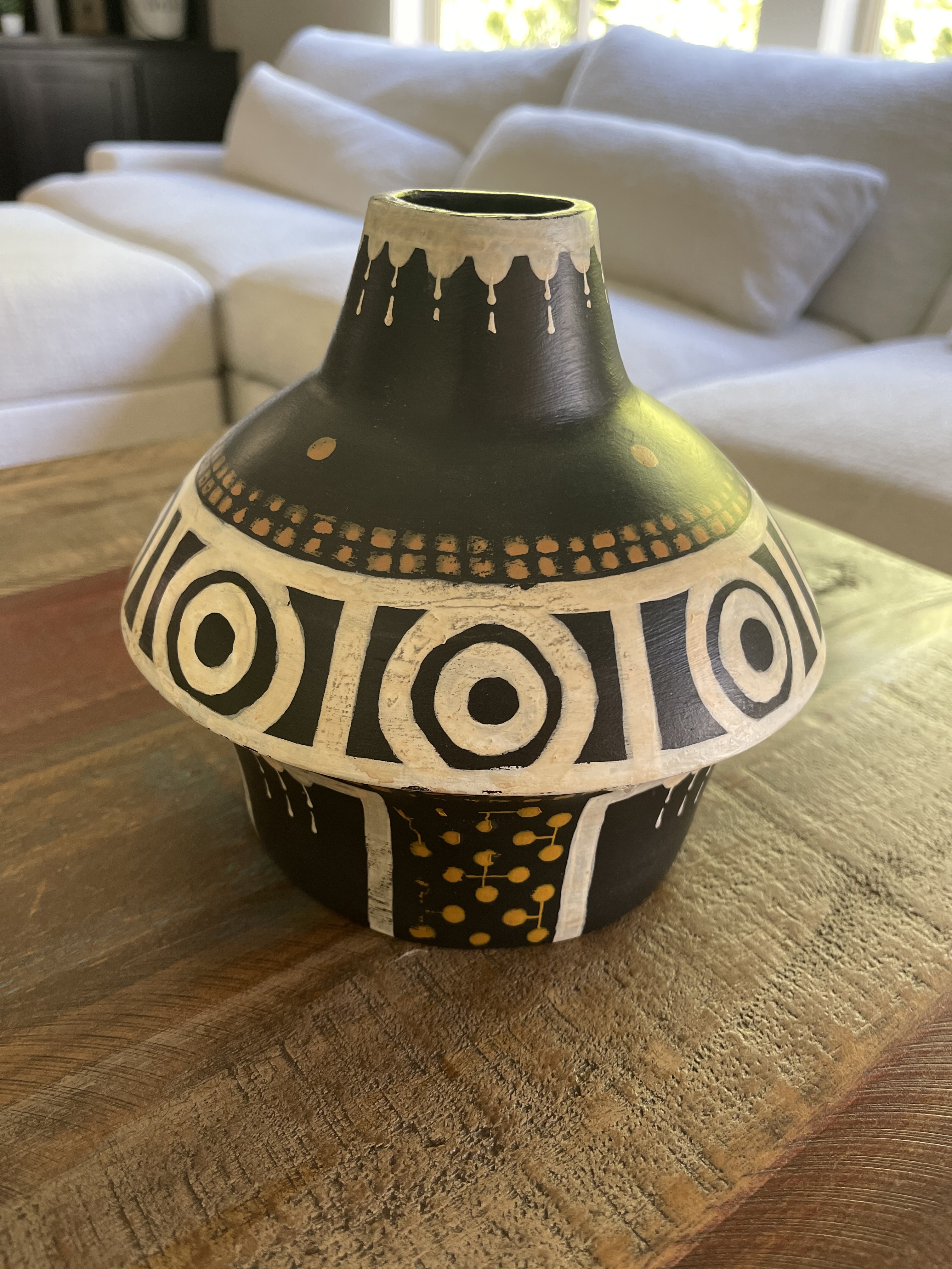 Black ceramic jug with white concentric-circle ornament and yellow details