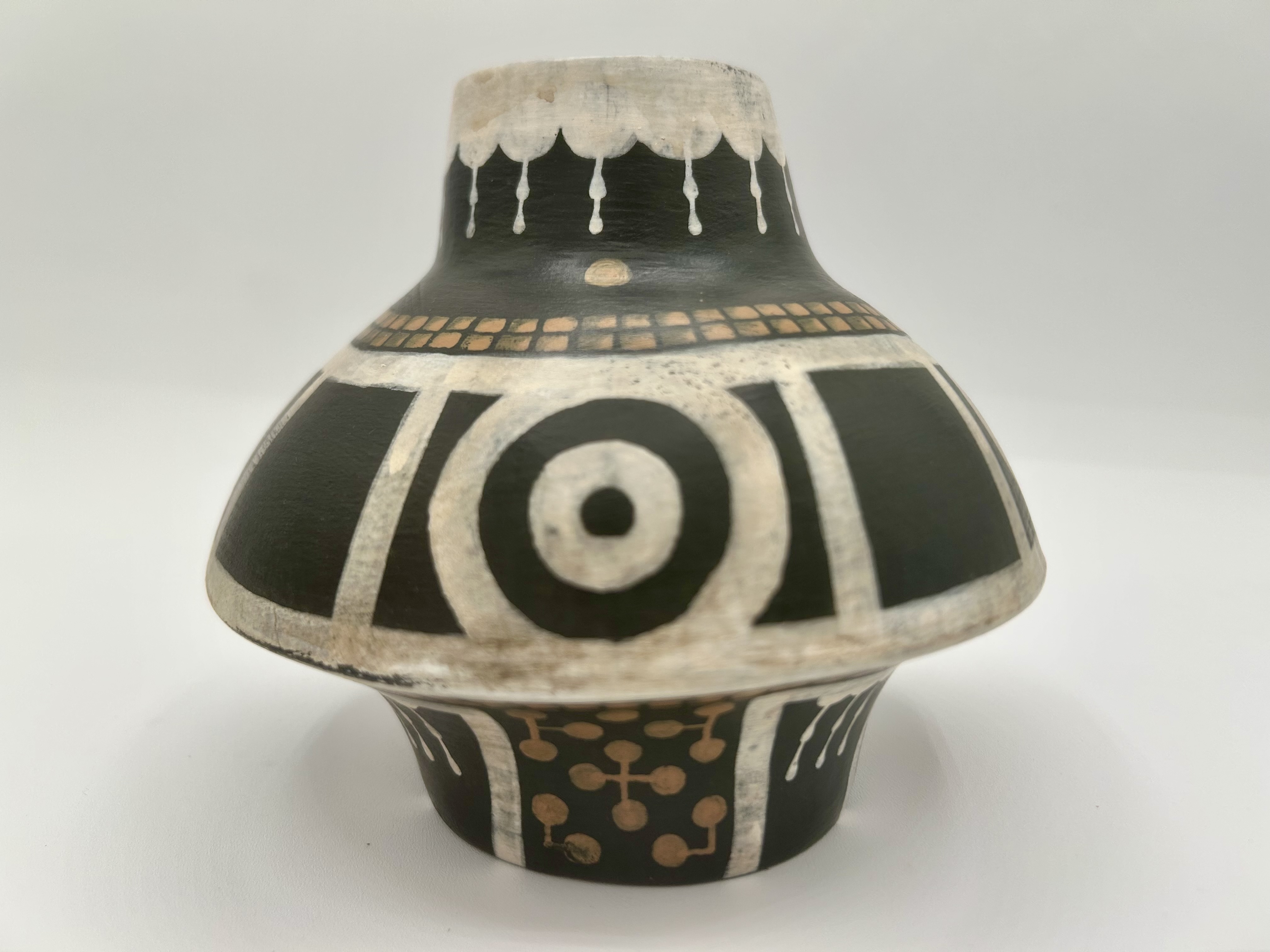 Close view of a black ceramic jug featuring a large white circular motif